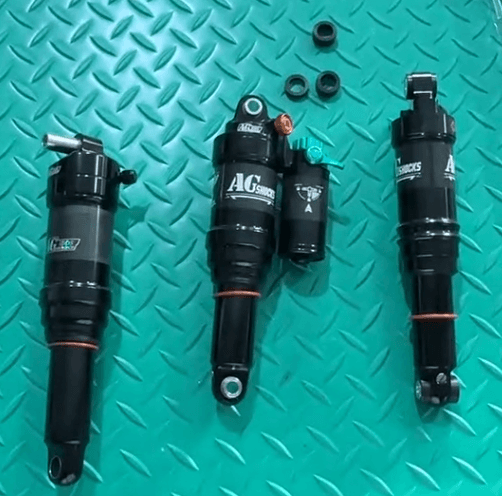 Rear shocks and mounting hardware laid out for comparison